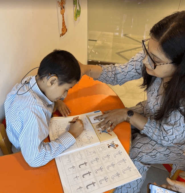 Child writing cursive letters on lined paper