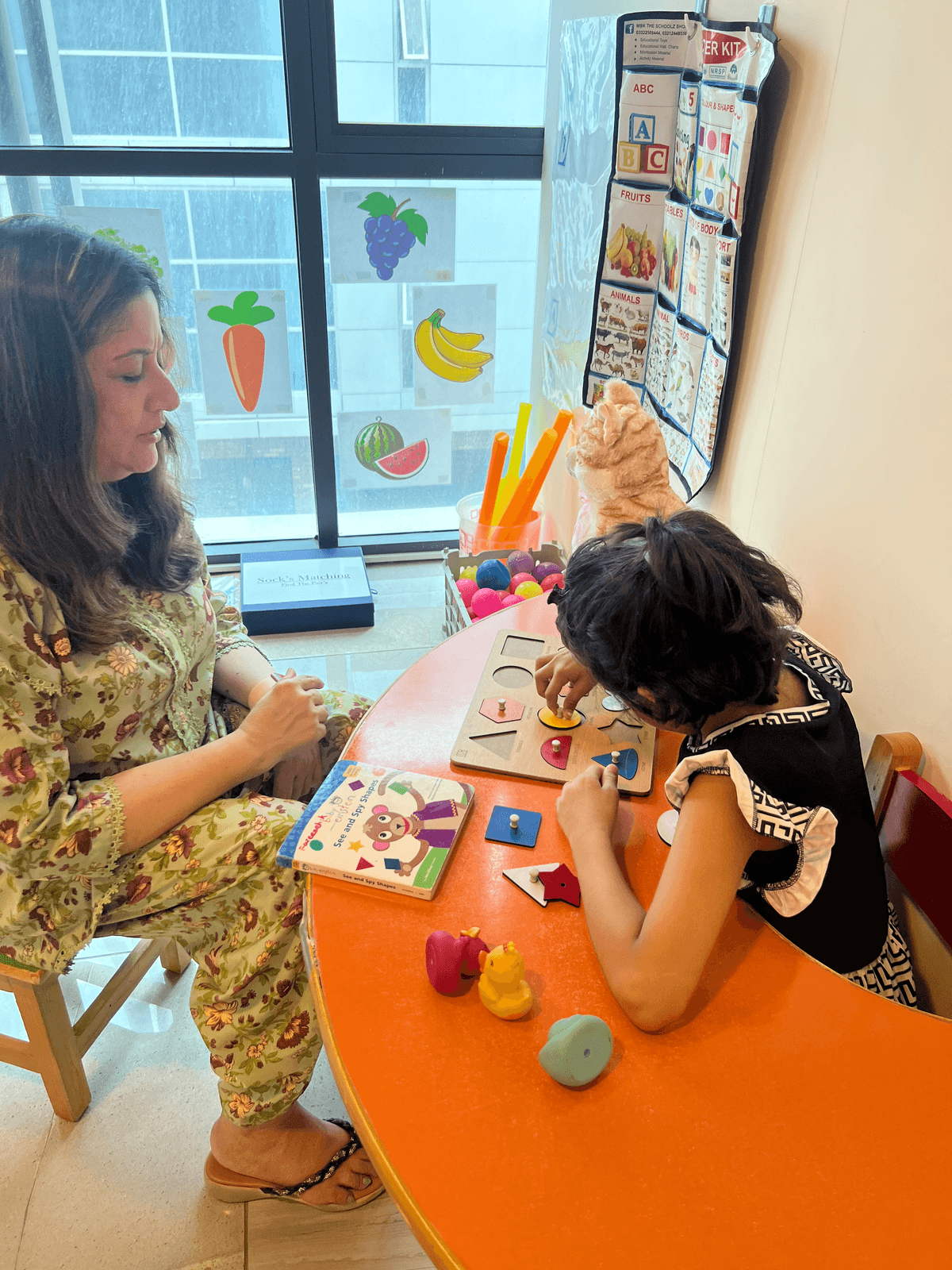 Boy stacking plastic rings on peg with therapist