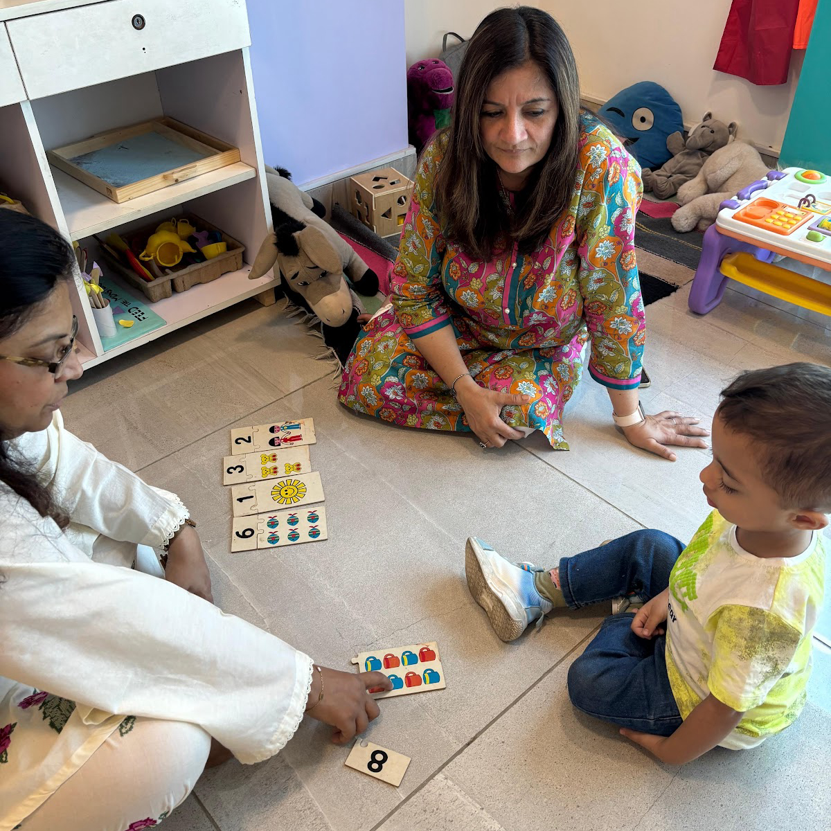 Learning Lab director and specialist engaging young learner through interactive puzzle activity